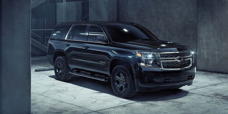 Chevrolet Tahoe parked in a dark space surrounded by walls